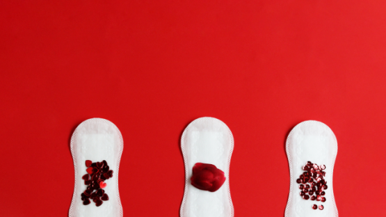 Three period pads with red glitter suggestive of a period stain