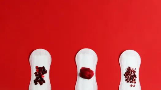 Three period pads with red glitter suggestive of a period stain