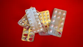 Generic silver blister pill packets on a red background