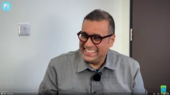 Gus - PI's executive director smiling in a video, tech pill logo in the bottom right corner